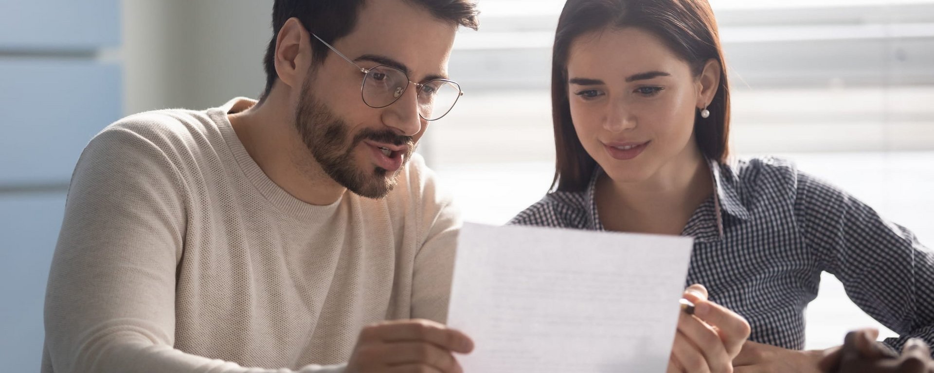 HEIM & HAUS Industriekaufleute schauen auf ein Blatt Papier