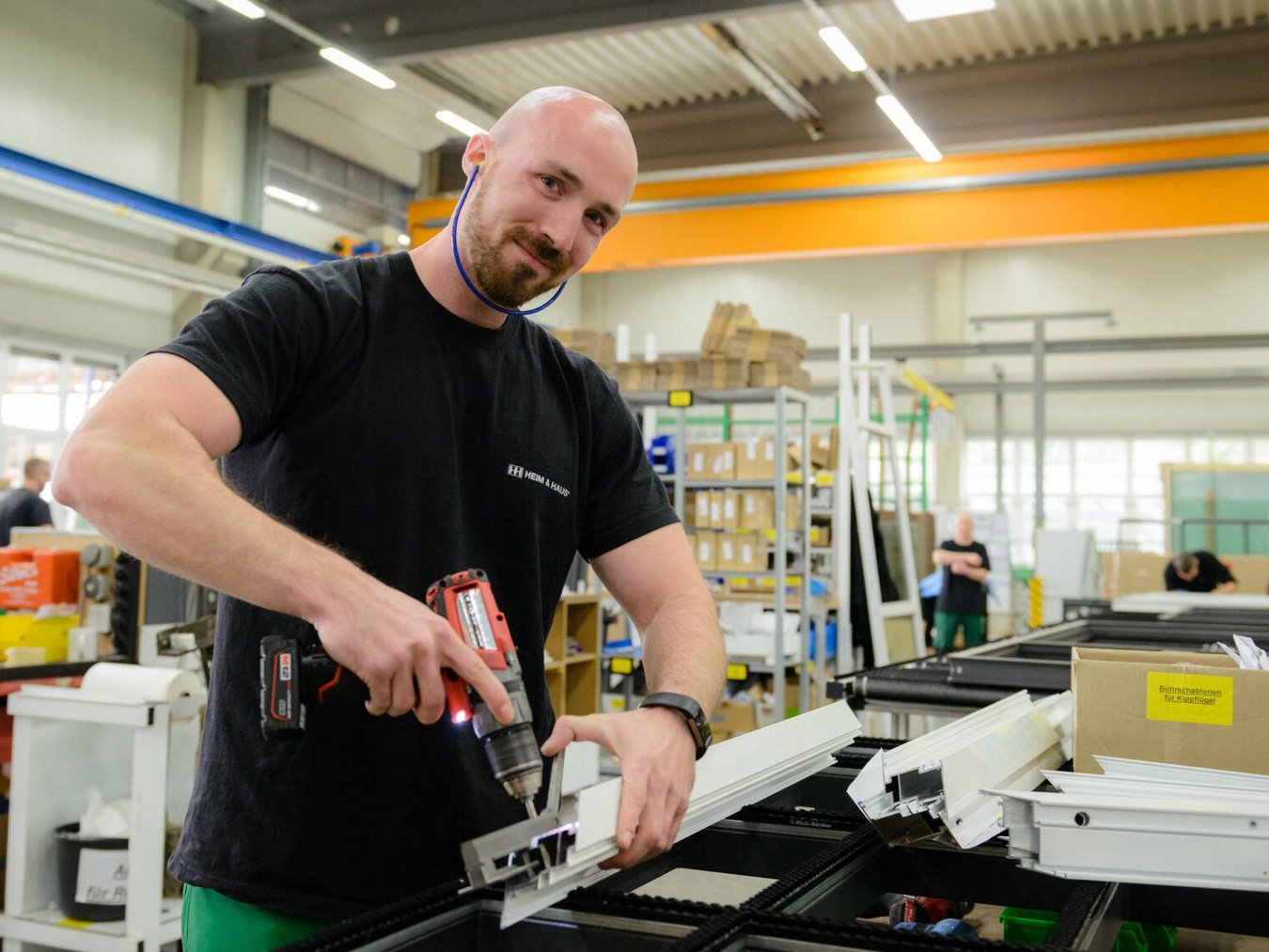 HEIM & HAUS Werksmitarbeiter aus dem Werk Osterfeld mit Bohrmaschine und Ohrschutz