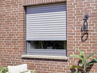 Die Kombination aus modernen Fenstern und Sonnenschutz sorgt für effektive Abkühlung Halb geschlossener Rollladen vor Kunststofffenster