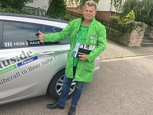 HEIM & HAUS Fachberater Herr Marmol vor einem HEIM & HAUS Auto