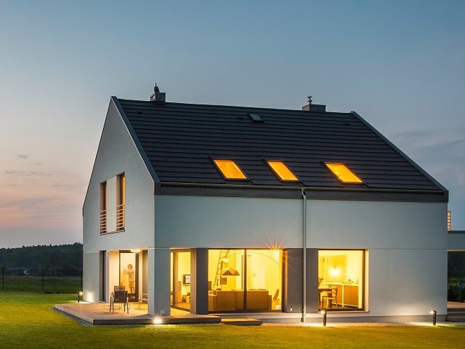 Smarte Beleuchtung sorgt im Winter für Sicherheit und Wohnkomfort Beleuchtetes Gebäude vor Abenddämmerung