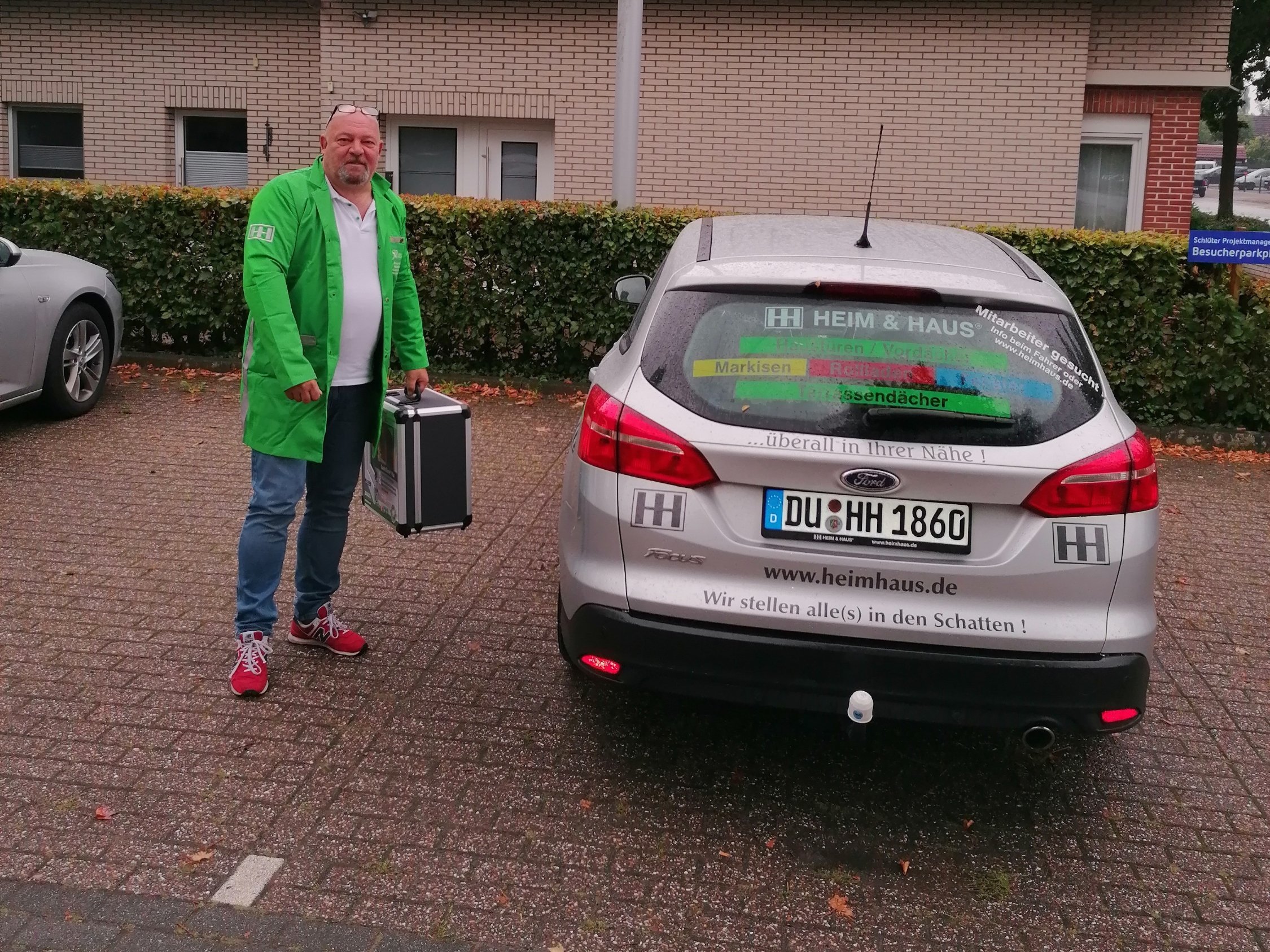 HEIM & HAUS Fachberater Herr Kiessler neben einem HEIM & HAUS Auto der Verkaufsleitung Bremen