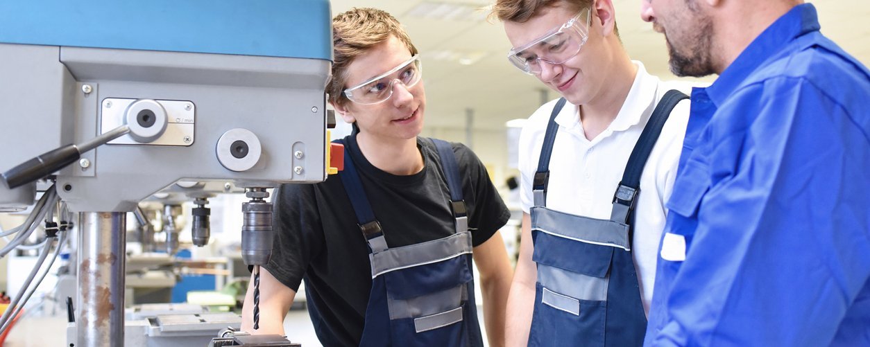 HEIM & HAUS 3 Auszubildende für Metalltechnik vor einer Maschine