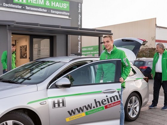 HEIM & HAUS Fachberater der Verkaufsleitung Frankfurt in der Tür eines Autos