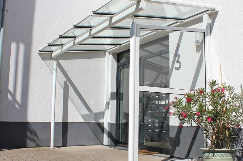 Vordach aus Acrylglas und Aluminium mit Seitenteilen