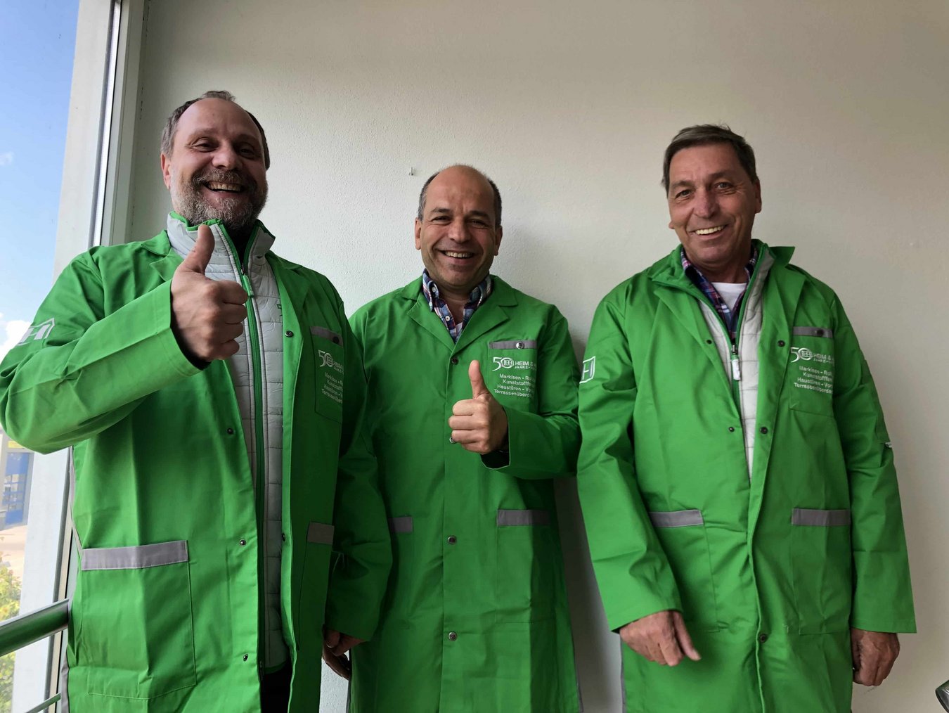 Drei HEIM & HAUS Fachberater aus der Verkaufsleitung Nürnberg mit grünen HEIM & HAUS Kitteln