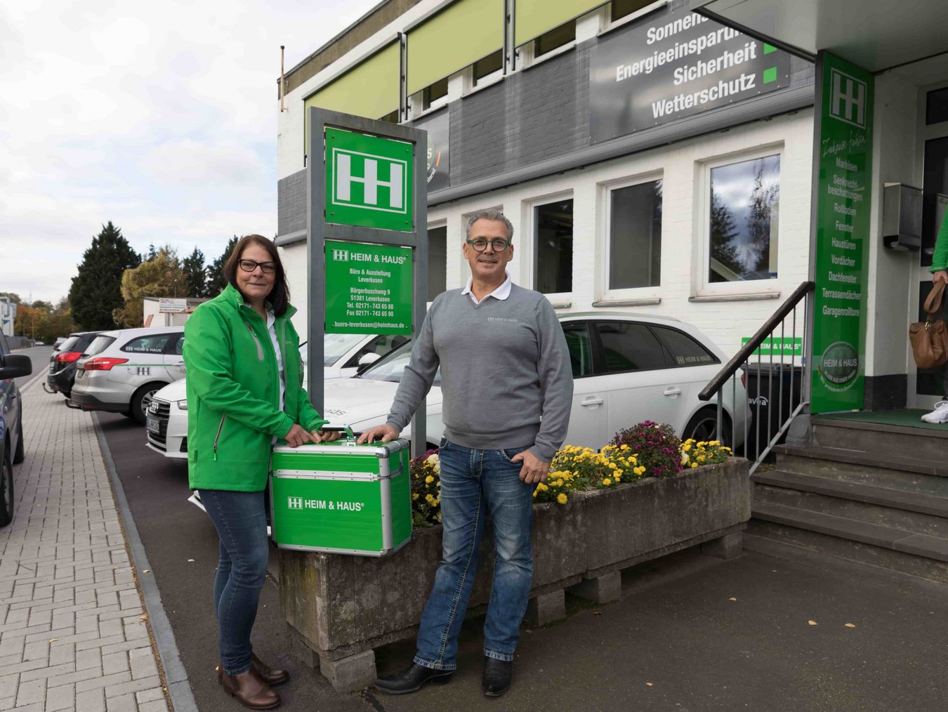 Zwei HEIM & HAUS Fachberater der Verkaufsleitung Leverkusen mit einem Koffer