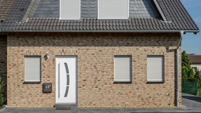 Haus in Straßenansicht mit geschlossenen Rollladen vor allen Fenstern