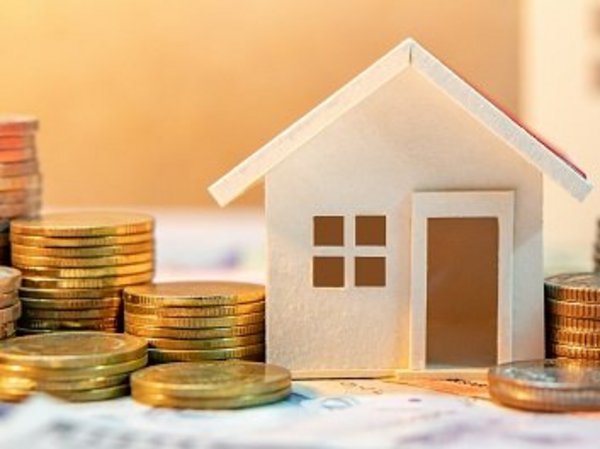 Kosten sparen beim Einbruchschutz Modellhaus neben Geldmünzen