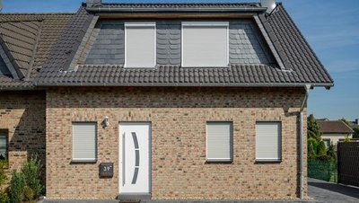 Fasssadenansicht mit Haustür und Fenster mit geschlossenen Rollladen