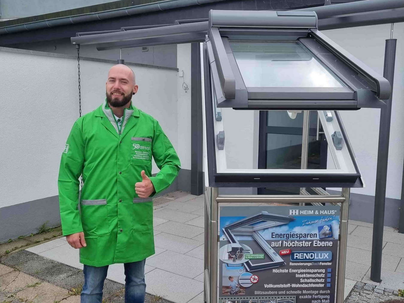 HEIM & HAUS Fachberater Herr Pfister der Verkaufsleitung Frankfurt an einem Dachfenster Exponat