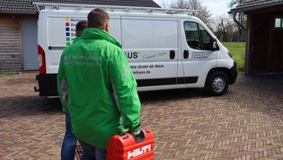 HEIM & HAUS Mitarbeiter aus dem Weg zu einem Montageauto und einem Werkzeugkoffer