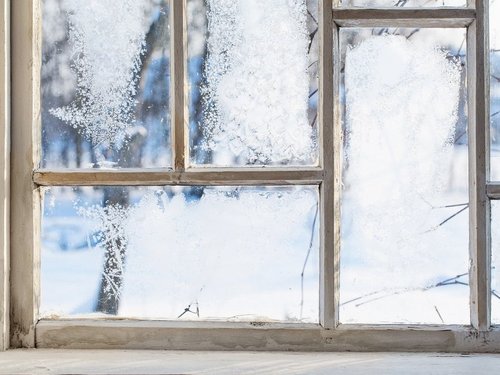 Holzfenster mit Frost an der Scheibe