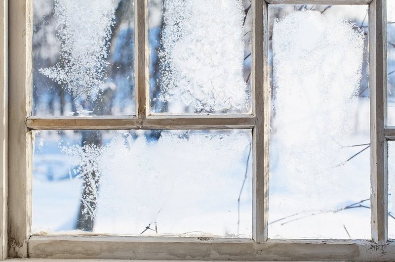 Holzfenster mit Frost an der Scheibe