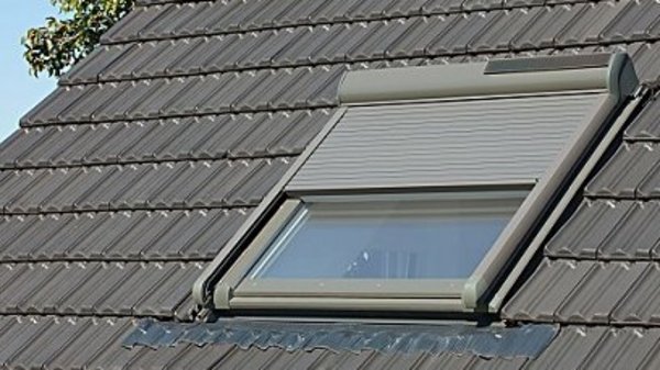 Dachfensterrollladen profitieren beim Solarantrieb von der exponierten Lage Dachfenster mit halb geschlossenem Dachfensterrollladen