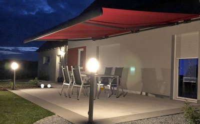 Die richtige Beleuchtung des Außenbereichs sorgt für Sicherheit und Wohnkomfort Terrasse mit Markise beleuchtet bei Nacht