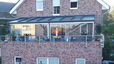 Terrassendach mit Wetterschutzelementen an Fassade