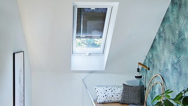 Dachfensterrollladen bieten Sonnenschutz und mehr Dachfenster mit halb geschlossenem Dachfensterrollladen über Sitzecke