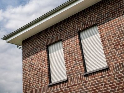 Dachüberstände und Fassenverkleidung schützen das Mauerwerk Fassade mit Dachüberstand und geschlossenen Rollladen