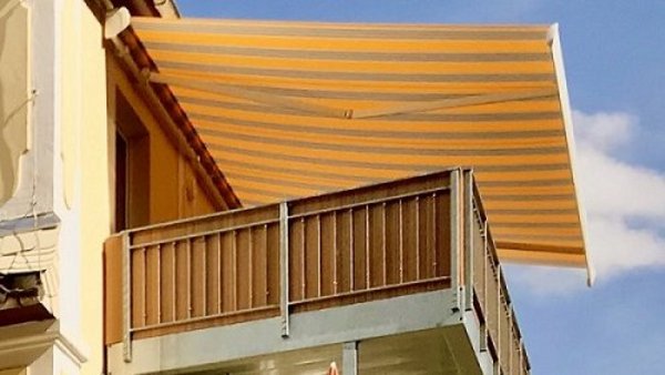 Beschattung von Balkonen gelingt mit Markisen Gestreifte Markise über freistehendem Balkon