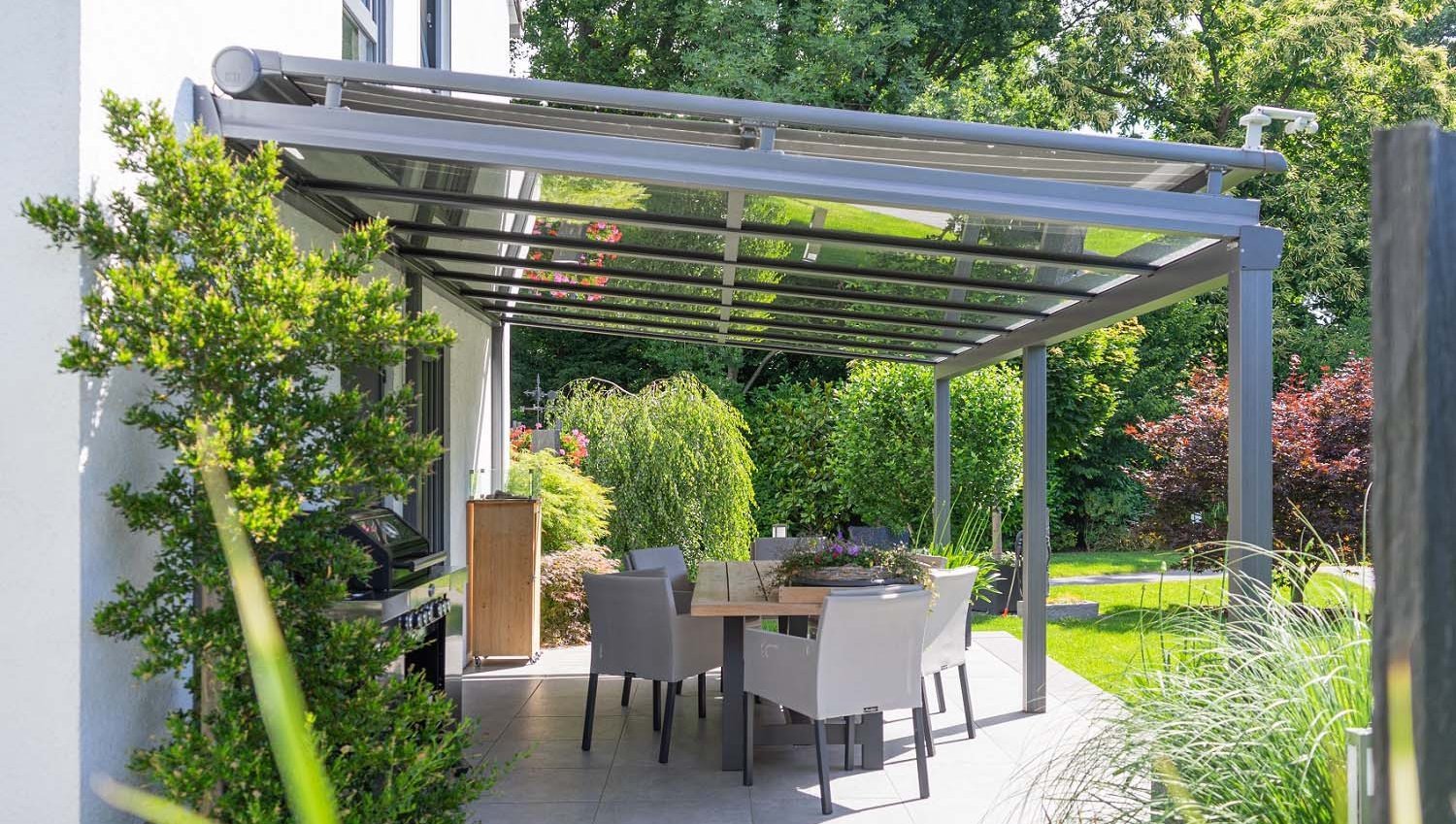 Seitlicher Blick auf Terrassendach aus Glas mit Wintergartenmarkise
