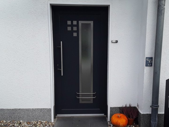 Dunkle Haustür an weißem Mauerwerk