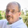 Mann der etwas montiert und in die Kamera schaut