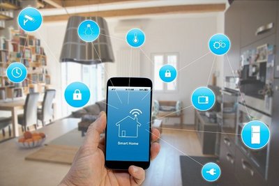Intelligente Vernetzung verschiedener Smart Home-Komponenten Hand hält Smartphone, vernetzte Smart Home-Icons um das Smartphone