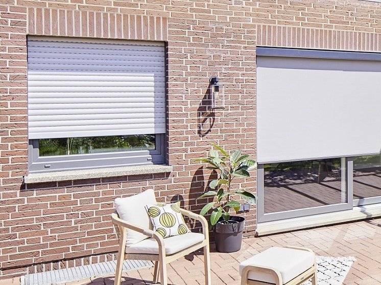 Moderne Fenster und außenliegender Sonnenschutz sorgen für angenehmes Wohnklima im Sommer Fassade mit Rollladen und Zipscreens vor Fenstern