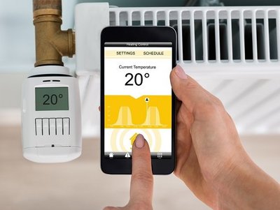 Smartes Thermostat an Heizkörper, Hand mit Smartphone