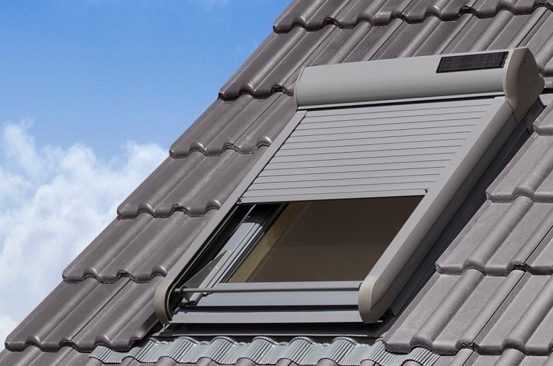 Halb geschossener Dachfensterrollladen mit Solarzelle