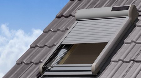 Halb geschossener Dachfensterrollladen mit Solarzelle
