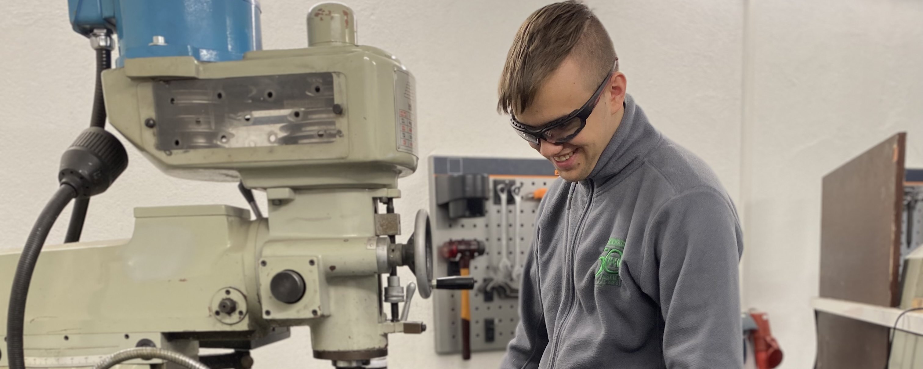 junger Mann vor Maschinenanlage