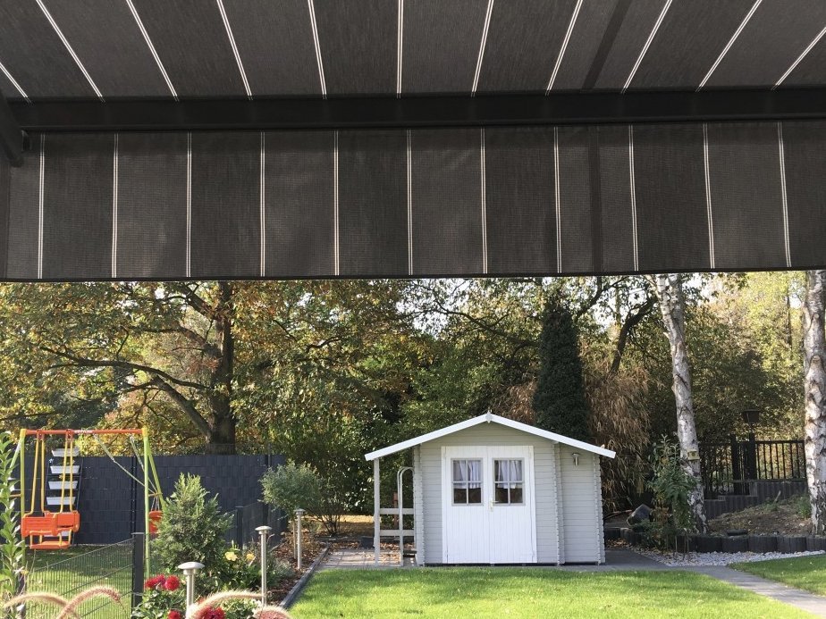 Blick unter Markise mit Volant in den Garten