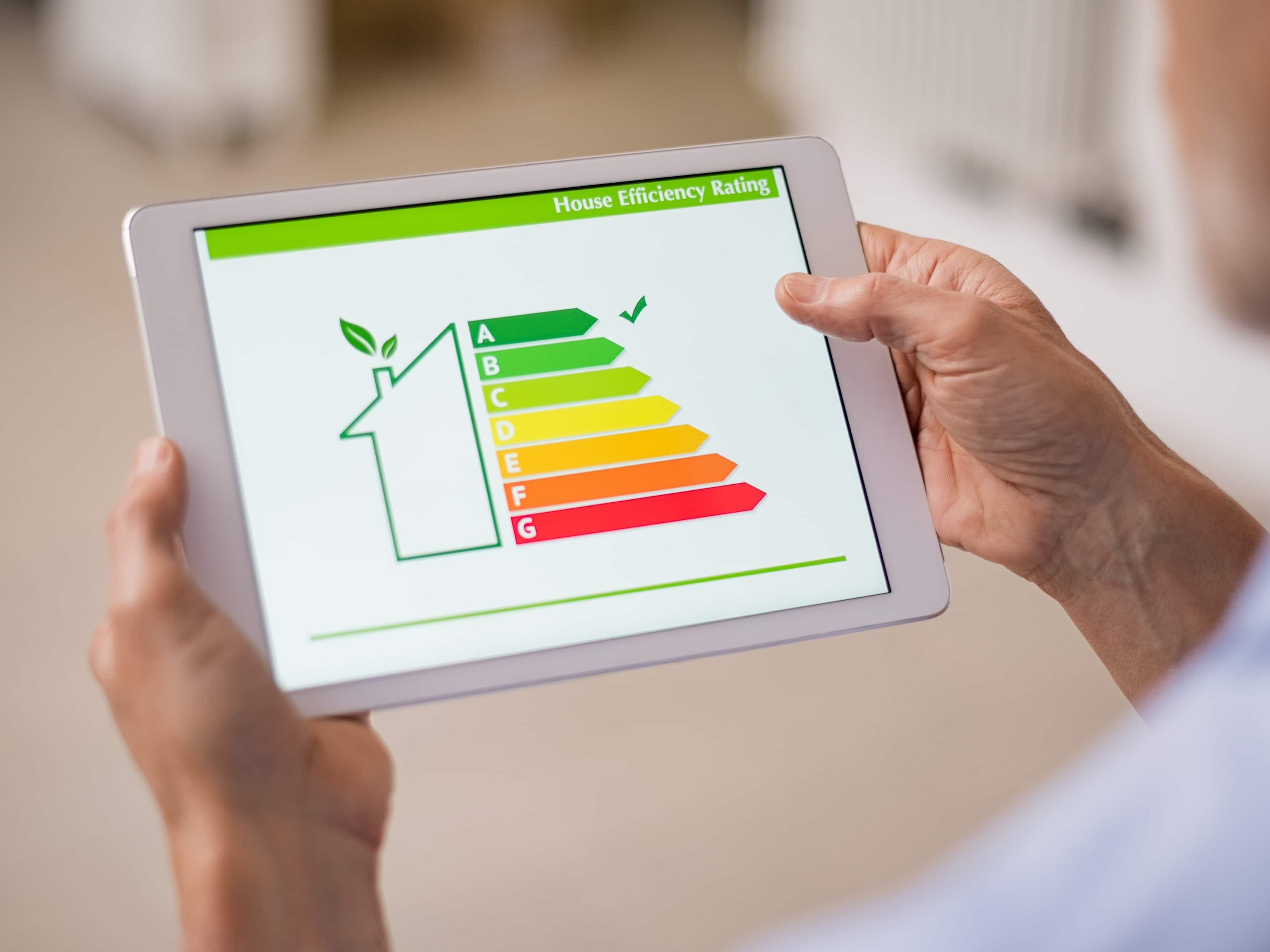 Energie sparen: Welche Maßnahmen sind am effektivsten? Energieeffizienz eines Hauses auf Tablet