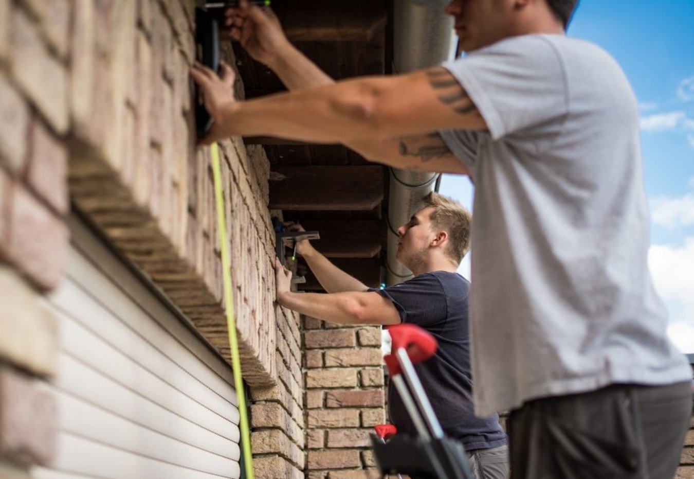 Handwerker, die etwas an der Außenwand ausmessen