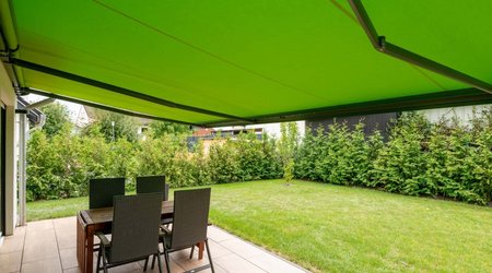 Gelenkarmmarkise mit grünem Markisentuch